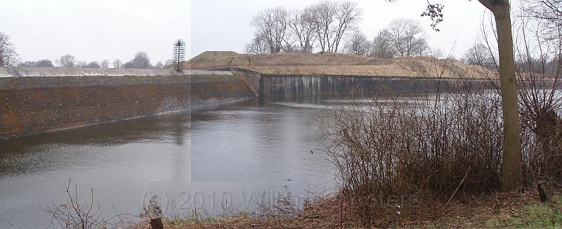 11-Dam.jpg - One of the dams - triangular in form: a wide base, leaning sides that for a sharp edge on top: almost impossible to cross; with the fortified walls on the other side of the water.