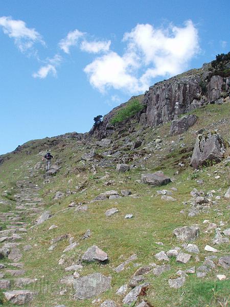 05-UpTheMountain.jpg - A stairway uphill, below rocky outcrops - crags - on the right.